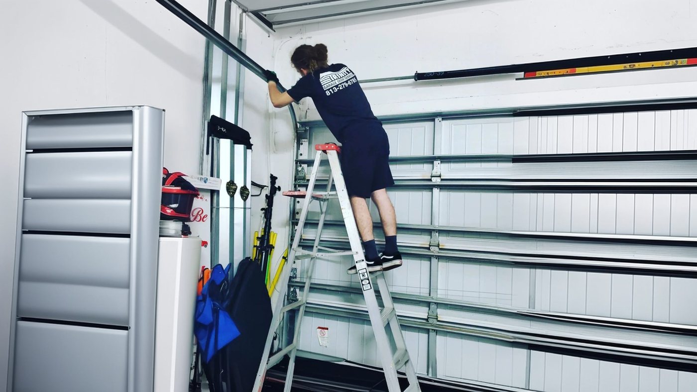 A Trinity technician checking the cables and track inside a garage
