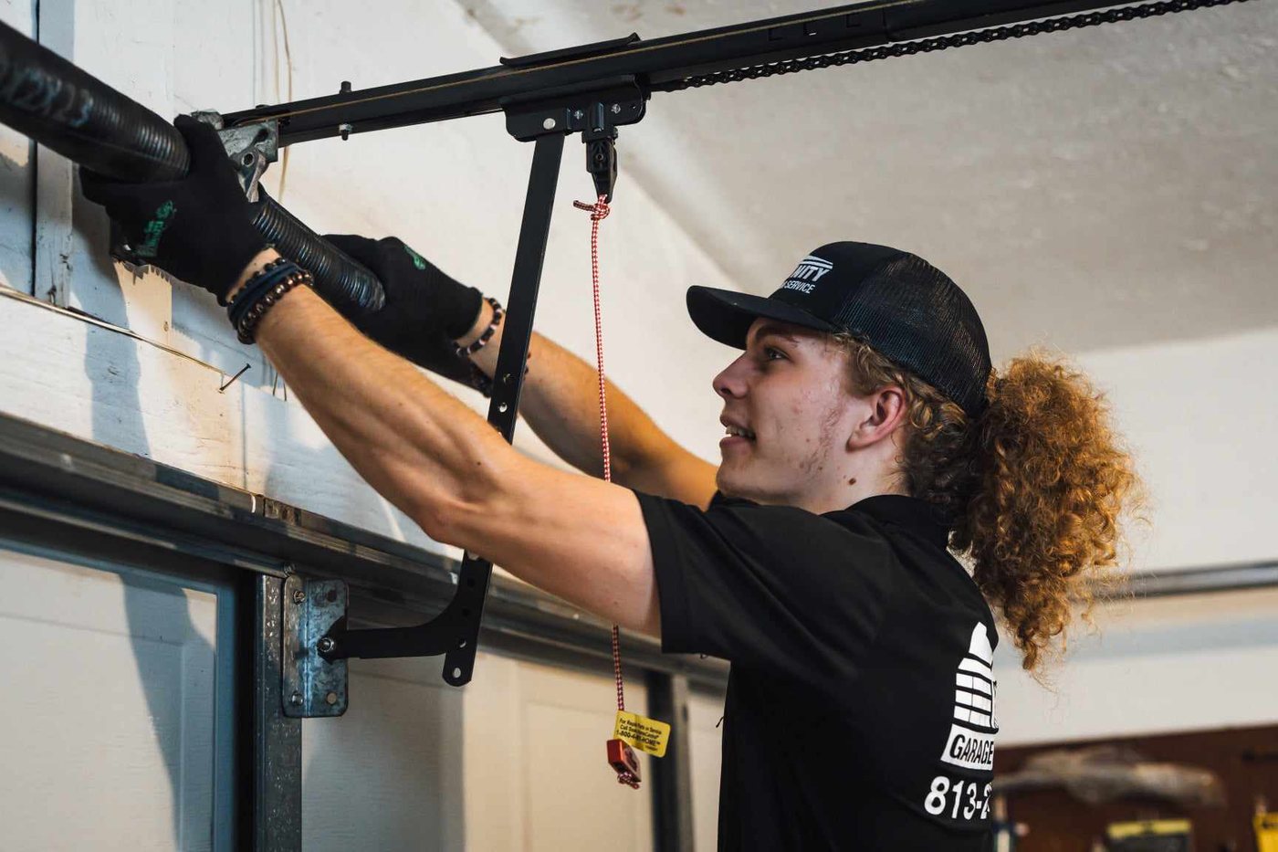 Trinity technician servicing and tuning up a garage door