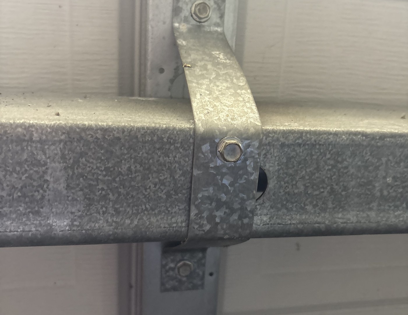 Close up of a garage door strut and hinge, the hardware checked on every tune up