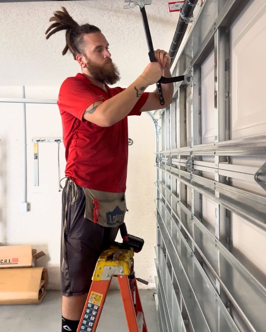 Trinity technician on a ladder servicing a door