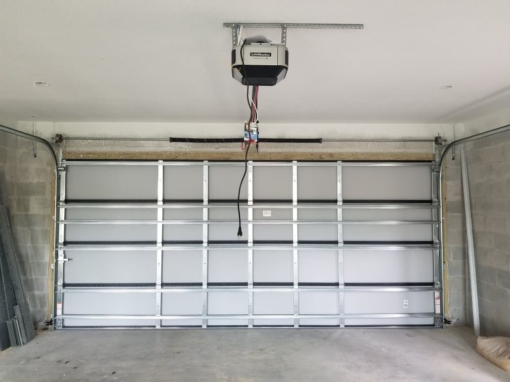 A garage door opener unit mounted above a finished white door