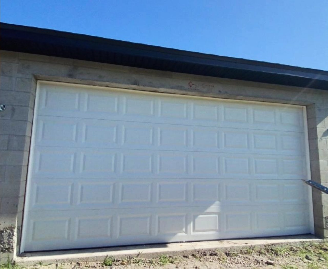 A white garage door set against dark exterior trim