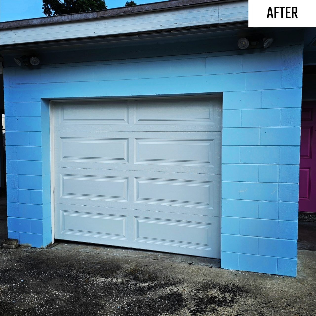 A white garage door on a blue block Florida home